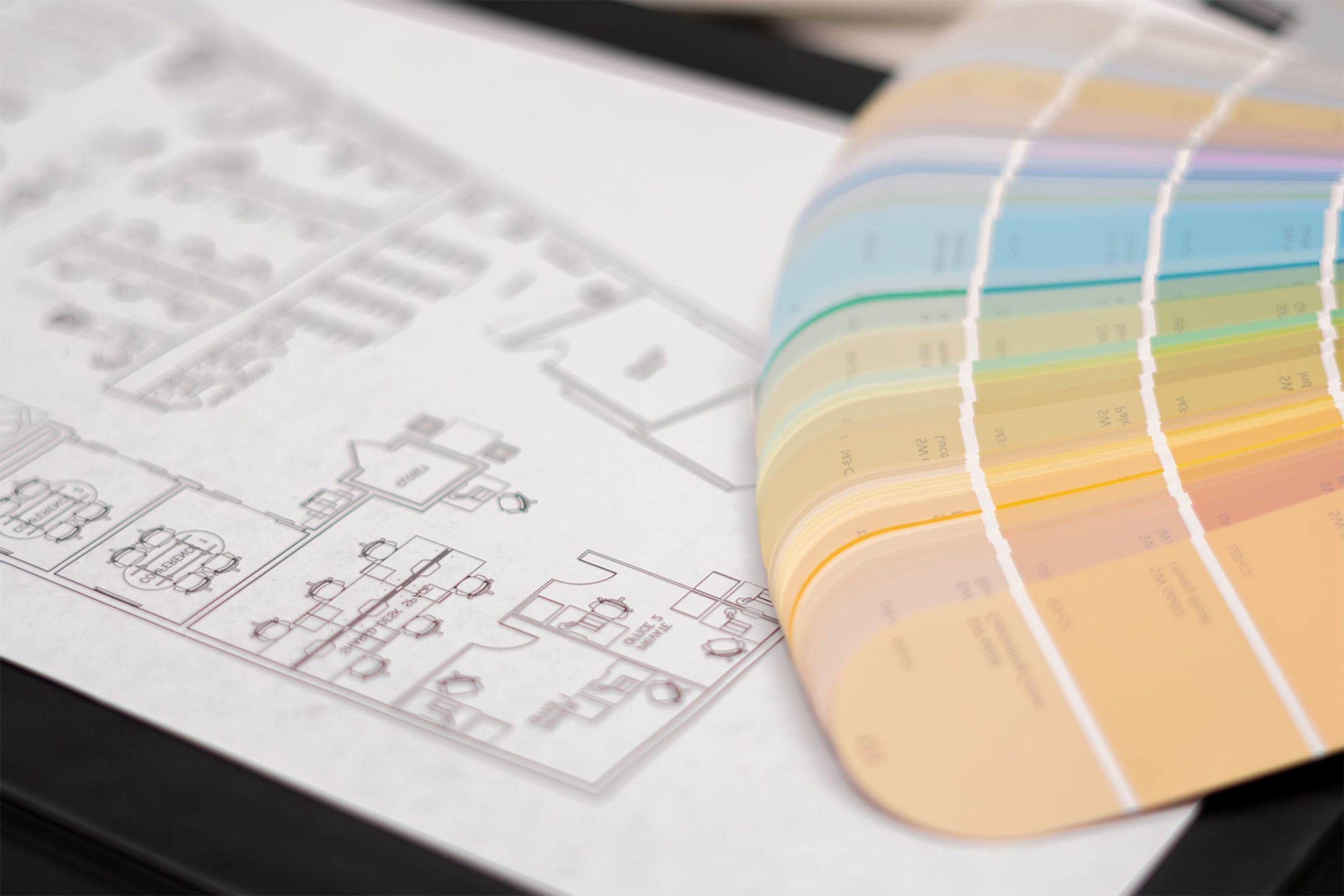 Tavolo di lavoro di un interior designer con planimetria della casa e palette di colori