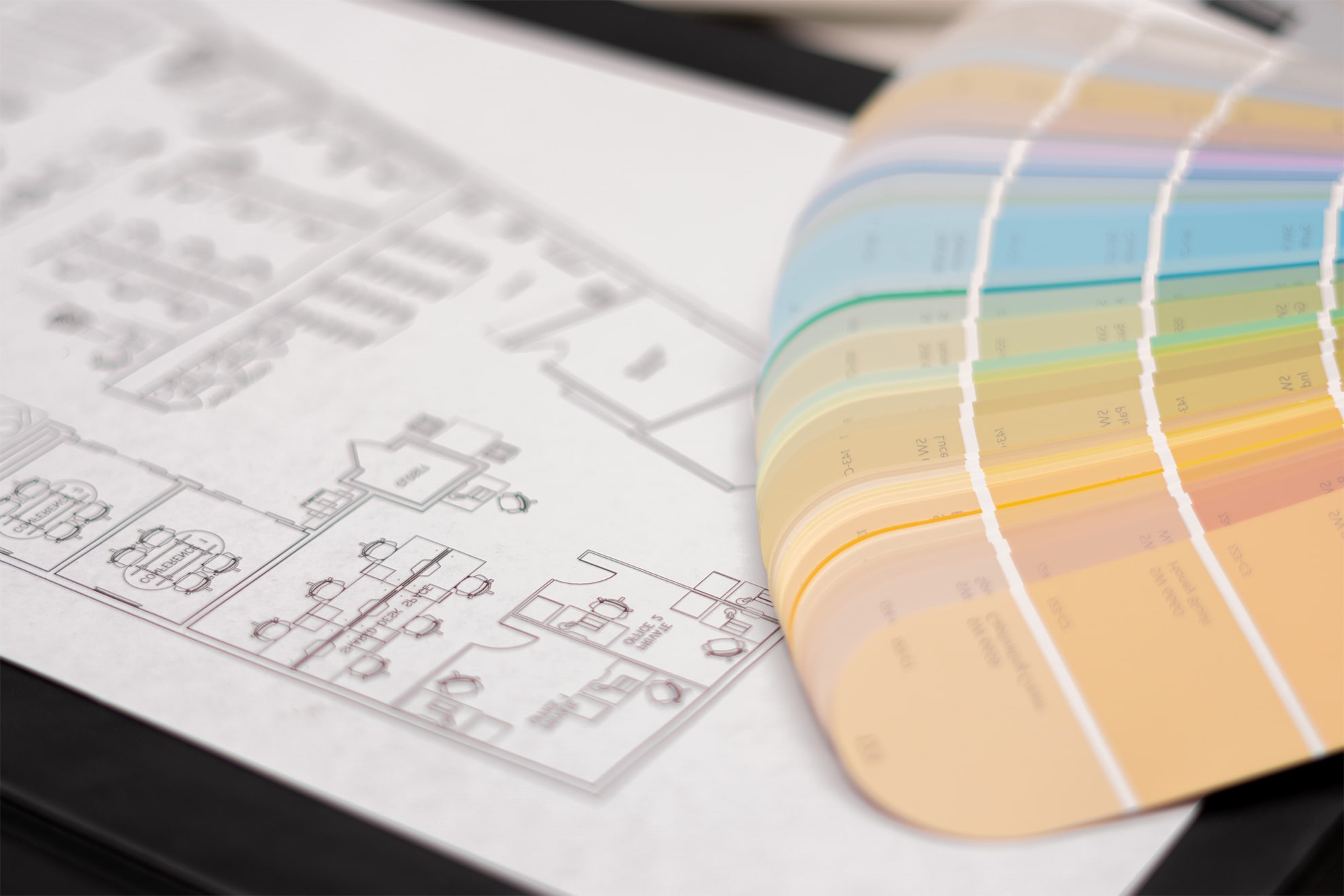 Tavolo di lavoro di un interior designer con planimetria della casa e palette di colori